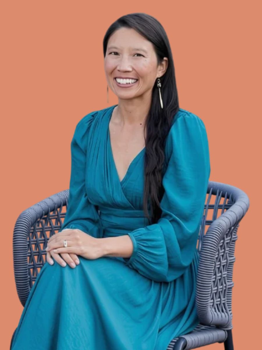 Jennie, founder of Chief Mama Officer, seated in a teal dress